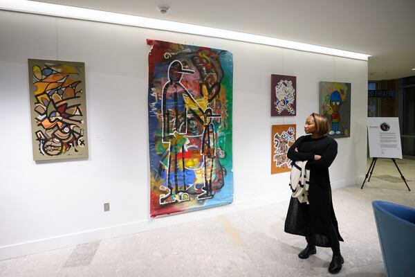 A visitor looks at the wok of artist Dakoro Edwards at Sandy Springs City Hall. (Jason Getz / jason.getz@ajc.com)