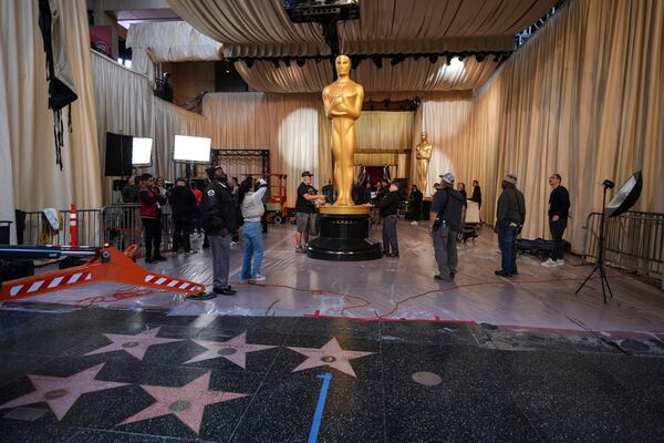 Workers set up an Oscar statue in the red carpet area before the 97th Academy Awards in Los Angeles, Saturday, March 1, 2025. (AP Photo/Jae C. Hong)