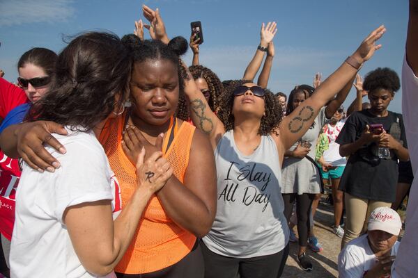 Adelaide Leao comforts Joslyn Huff while worshiping during the OneRace event on top of Stone Mountain Saturday, August 25, 2018. STEVE SCHAEFER / SPECIAL TO THE AJC