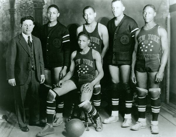 In the 1920s, Abe Saperstein, left, a sports booking agent, became the owner of the Harlem Globetrotters. He's shown here with the core members of the early Globetrotters team. (Courtesy of the Harlem Globetrotters)
