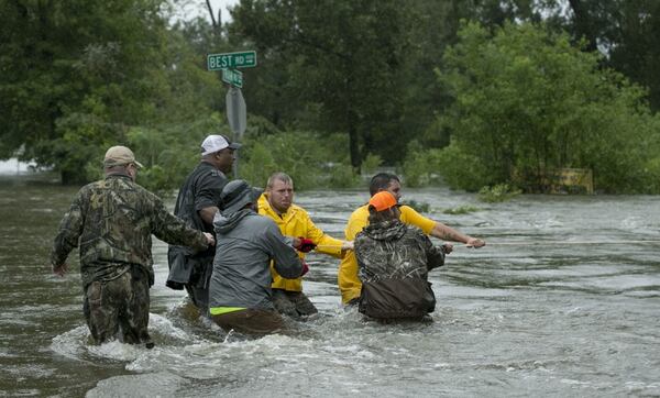 Volunteers help handle a boat in a swift current during the rescue of people from their homes after Tropical Storm Harvey flooded Beaumont last week. JAY JANNER / AMERICAN-STATESMAN