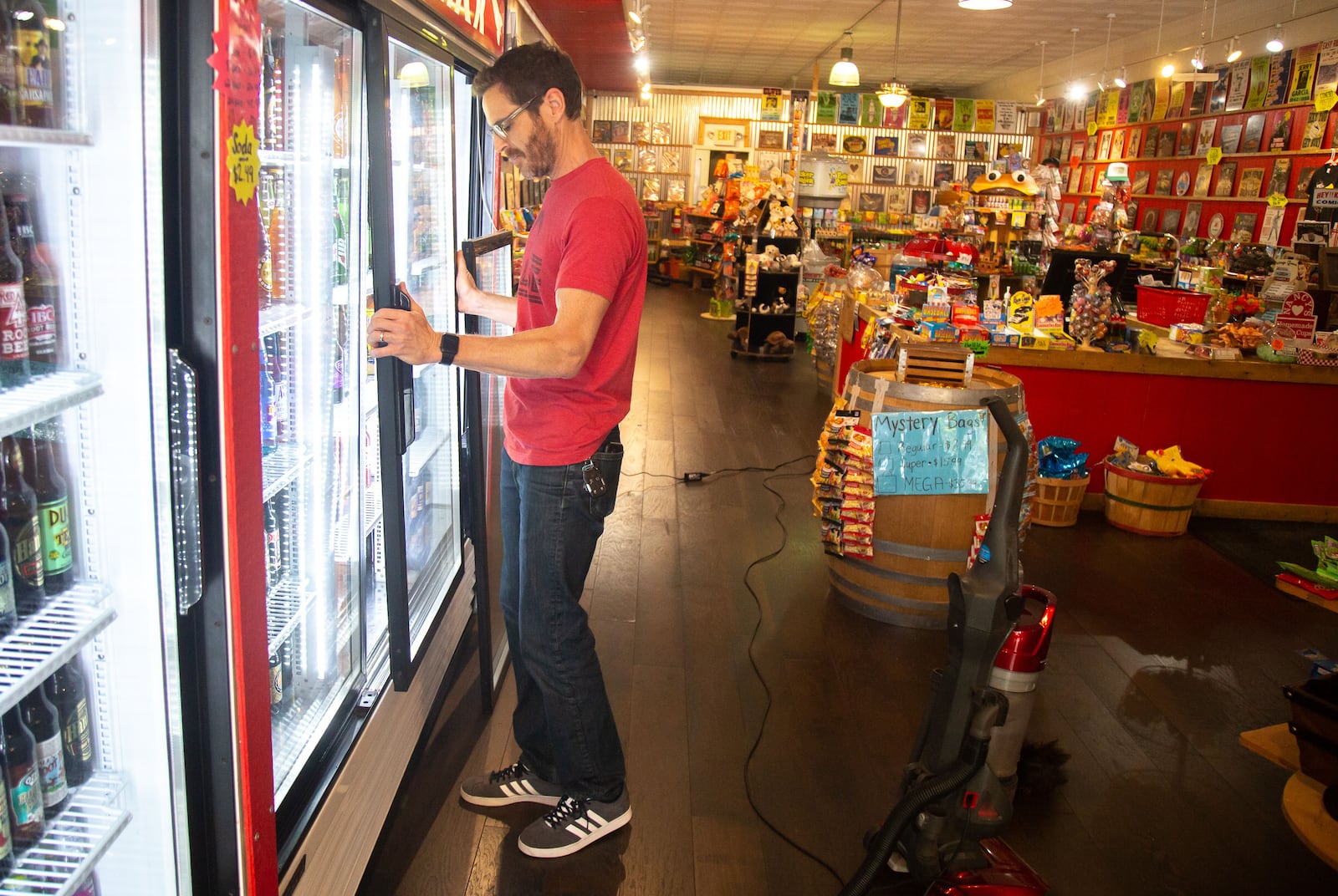 Rocket Fizz owner Stephan Nelson cleans up his Marietta Square store in preparation for his reopening Monday. STEVE SCHAEFER / SPECIAL TO THE AJC