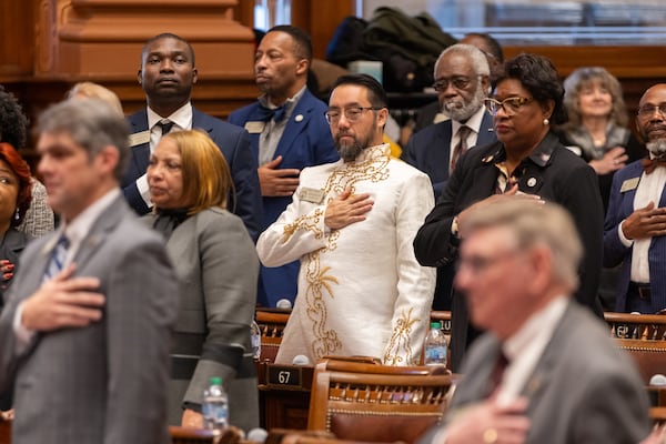 Georgia state representatives, including Rep. Long Tran, a Democrat from Dunwoody, place their hands on their hearts for the national anthem on the first day of the legislative session at Capitol in Atlanta on Monday.