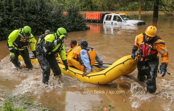 Atlanta watershed employees were rescued from the flooded Peachtree Creek near Woodward Way. JOHN SPINK / JSPINK@AJC.COM