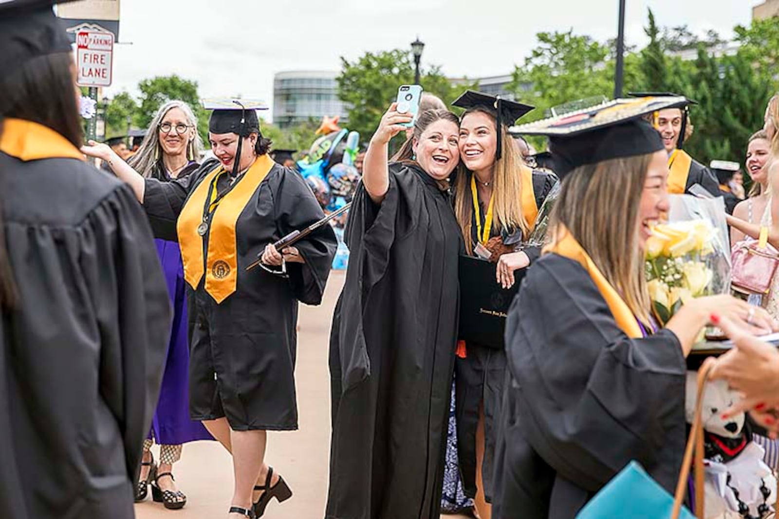 05/09/2019  -- Kennesaw, Georgia -- Kennesaw State University Prof. Amanda Wansa Morgan (center) takes a selfie with KSU alumnus Shannon Murphy (right) following the 223rd Kennesaw State University commencement ceremony at the convocation center on the university's main campus in Kennesaw, Thursday, May 9, 2019. (ALYSSA POINTER/ALYSSA.POINTER@AJC.COM)