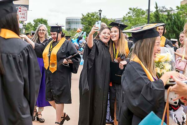 Kennesaw State University Prof. Amanda Wansa Morgan (center) takes a selfie with KSU alumnus Shannon Murphy (right) following the 223rd Kennesaw State University commencement ceremony at the convocation center on the university's main campus in Kennesaw, Thursday, May 9, 2019. 