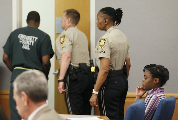 April 25, 2019 - Lawrenceville - Emani Moss’ father, Eman Moss, is escorted from court after he testified at his wife’s capital murder trial. Tiffany Moss (right) showed little emotion during his testimony. Eman Moss agreed to a plea deal that allowed him to avoid the penalty in exchange for testifying against Tiffany Moss.