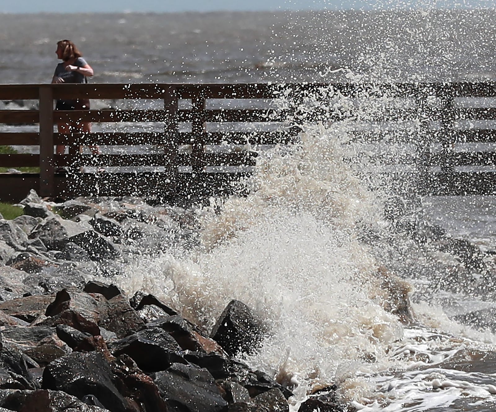 A woman turns away as she gets sprayed by a crashing wave from the outer edge of Hurricane Dorian at St. Simons Island on Sept. 3. CURTIS COMPTON / CCOMPTON@AJC.COM