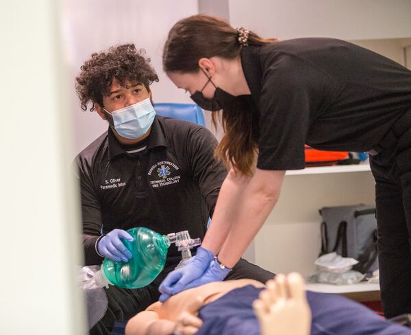 Paramedic students, including Samuel Oliver (seated) and Caitlin Crete (right) work Tuesday, Jan. 26, 2021, in Georgia Northwestern Technical College's ambulance simulation with technology allowing the instructor to adjust the body vitals so students can adjust in real time to changing medical conditions. (Jenni Girtman for The Atlanta Journal-Constitution)