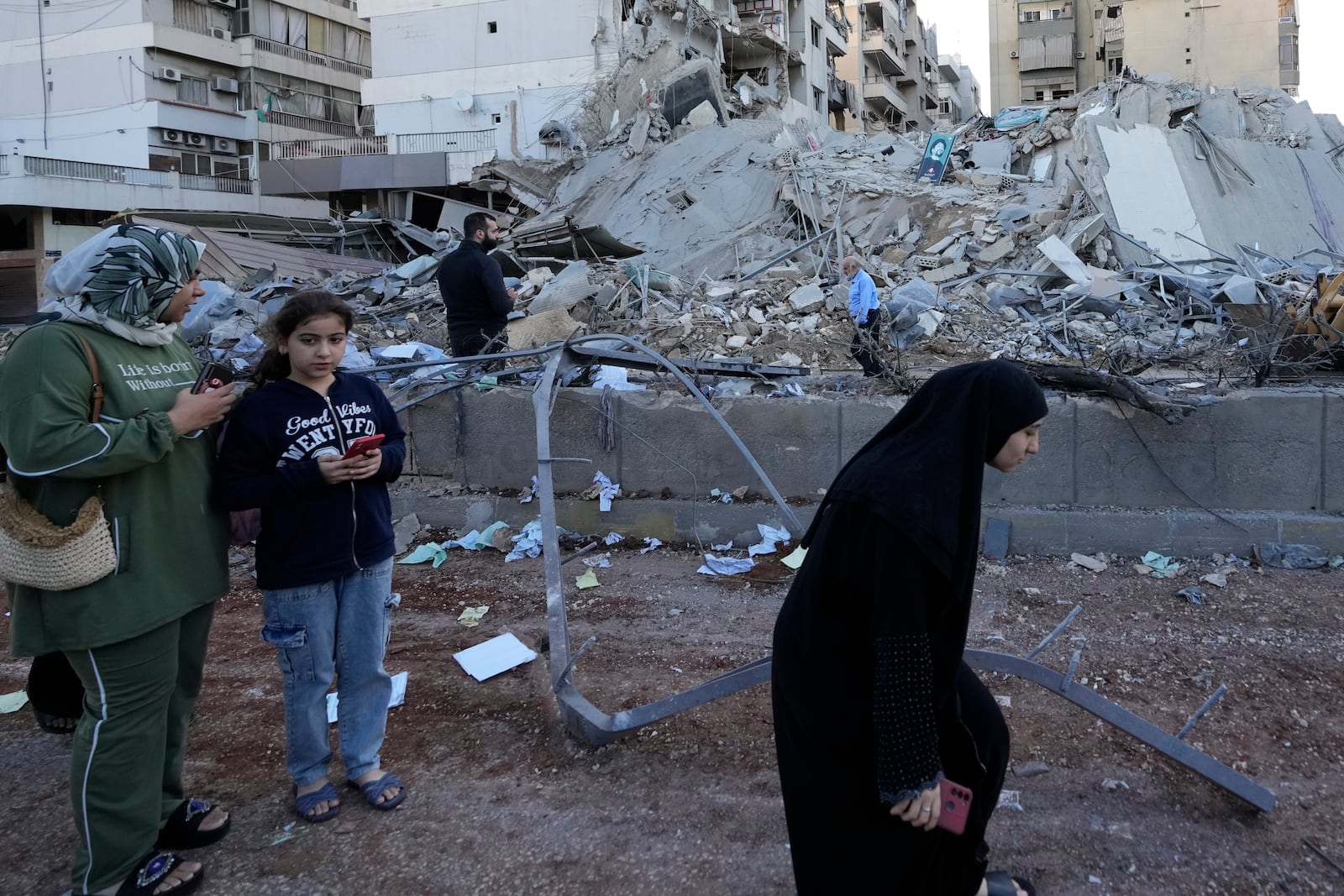 Residents check destroyed buildings at the site of an Israeli airstrike in Dahiyeh, Beirut, Lebanon, Monday, Oct. 21, 2024. (AP Photo/Hassan Ammar)