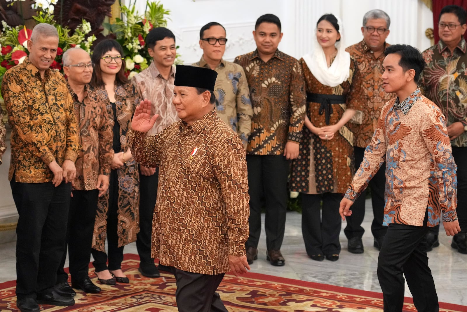 Indonesia's new President Prabowo Subianto, foreground, and Vice President Gibran Rakabuming Raka, right, greet newly-appointed deputy ministers during the announcement of their cabinet lineup at Merdeka Palace in Jakarta, Indonesia, Sunday, Oct. 20, 2024. (AP Photo/Achmad Ibrahim)