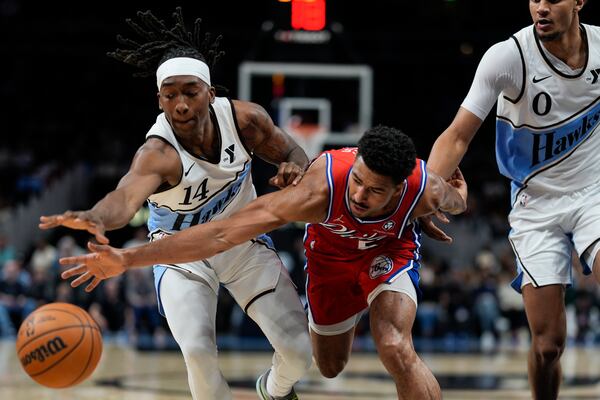 Atlanta Hawks guard Terance Mann (14) steals the ball from Philadelphia 76ers guard Quentin Grimes (5) during the first half of an NBA basketball game, Sunday, March 23, 2025, in Atlanta. (AP Photo/Mike Stewart)