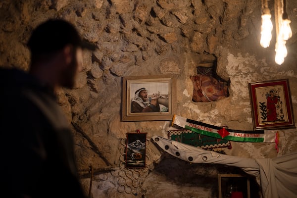 Salem Adra, brother of Palestinian activist Basel Adra, who won Best Documentary Feature at the Oscars for "No Other Land", looks at the photo of their father, hanging on a wall at a house where they usually gather for meetings at the West Bank village of Tuwani, Monday, March 3, 2025. (AP Photo/Leo Correa)