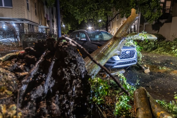 A downed tree lays across a car on Montag Circle in Atlanta, as seen Thursday morning, Sept. 26, 2024, before the arrival of Hurricane Helene. (John Spink/AJC)