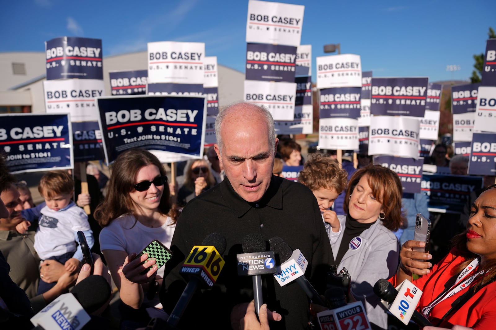 Sen. Bob Casey, D-Pa., left, stops to speak to members of the media before voting, Tuesday, Nov. 5, 2024, in Scranton, Pa. (AP Photo/Matt Rourke)