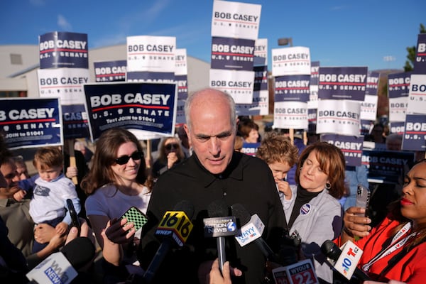 Sen. Bob Casey, D-Pa., left, stops to speak to members of the media before voting, Tuesday, Nov. 5, 2024, in Scranton, Pa. (AP Photo/Matt Rourke)