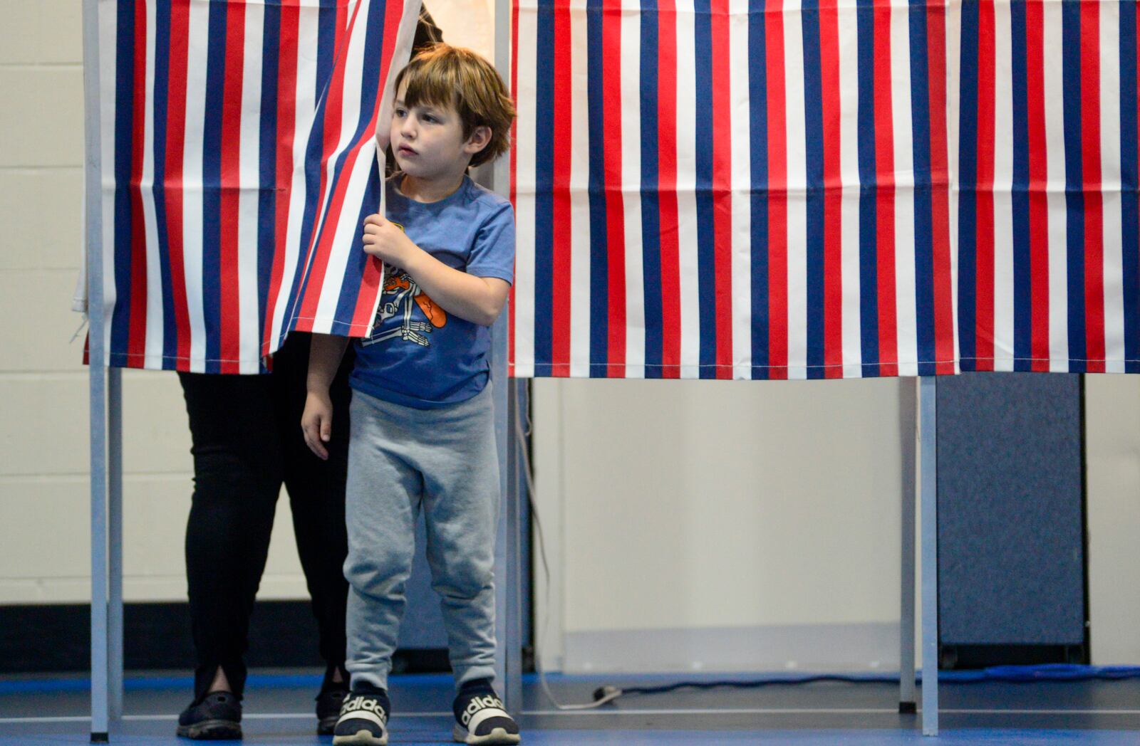 Max Florio, 5, of Chesterfield, N.H., stands just outside the voting booth while his mother, Rufina Tukmametova, fills out her ballot at the polling station in the elementary school on Election Day on Tuesday, Nov. 5, 2024. (Kristopher Radder/The Brattleboro Reformer via AP)