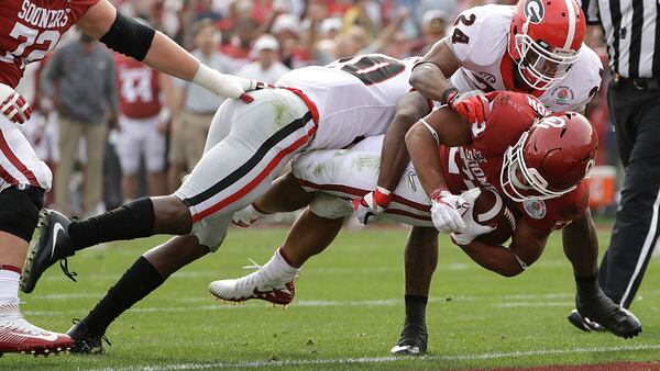 Oklahoma running back Rodney Anderson dives for a touchdown between Georgia defensive back J.R. Reed (left) and safety Dominick Sanders (right) during the first half of the Rose Bowl Monday, Jan. 1, 2018, in Pasadena, Calif. (Gregory Bull/AP)