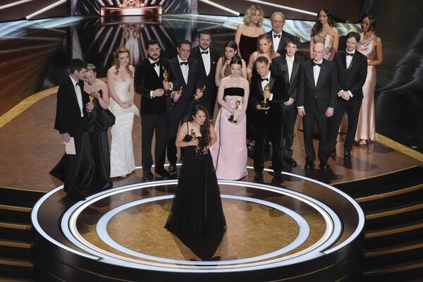 Samantha Quan (front center) accepts the award for best picture for "Anora" during the Oscars on Sunday, March 2, 2025, at the Dolby Theatre in Los Angeles. Alex Coco (from rear left), Darya Ekamasova, Lindsey Normington, Vache Tovmasyan, Karren Karagulian, Vincent Radwinsky, Luna Sofía Miranda, Mikey Madison, Sean Baker, Mark Eydelshteyn, Yura Borisov, Meg Ryan and Billy Crystal look on from the back. (Chris Pizzello/AP)