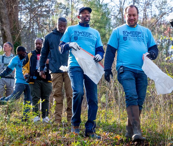 Atlanta Councilmember Dustin Hillis (right) and  Mayor of Atlanta Andre Dickens (Center) head for the river with the other volunteers at the start of  Sweep The Hooch day at Proctor Creek at Grove Park Saturday, March 26, 2022. Proctor Creek runs through Atlanta and ultimately empties into the Chattahoochee River.  STEVE SCHAEFER FOR THE ATLANTA JOURNAL-CONSTITUTION