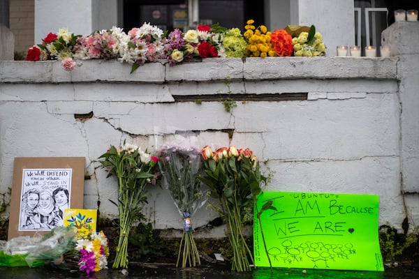 03/17/2021 —Atlanta, Georgia — Flowers and signs are displayed at a makeshift memorial outside of the  Gold Spa in Atlanta, Wednesday, March 17, 2021.  (Alyssa Pointer / Alyssa.Pointer@ajc.com)