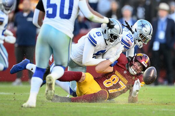 Washington Commanders tight end John Bates (87) fumbles during the second half of an NFL football game against the Dallas Cowboys, Sunday, Nov. 24, 2024, in Landover, Md. (AP Photo/Nick Wass)