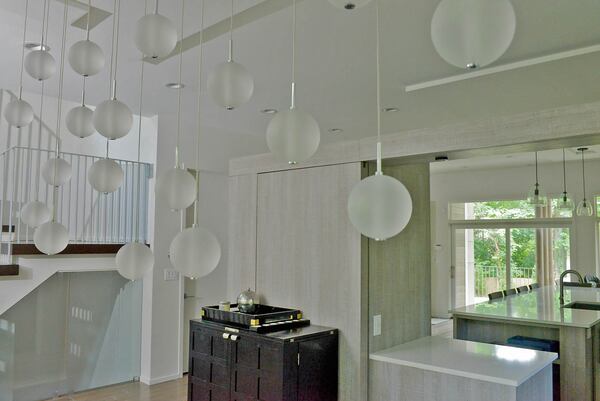 A bar in the dining room backs up to one of two sliding modern barn doors, which can be closed to create a separate space from the kitchen.