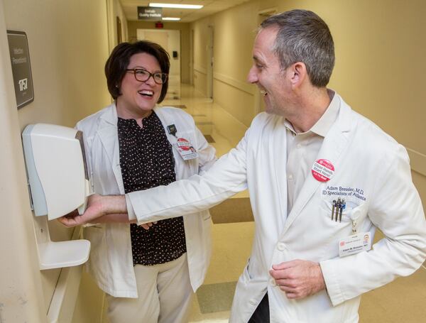 Jennifer Shankweiler and Dr. Adam Bressler chat near a hand sanitation station at Dekalb Medical Center. Photo by Phil Skinner.