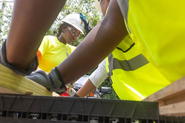 Crew Foreman Shayla Thomas, observes the length of wood while working on a construction site on August 2, 2023 in Atlanta. Thomas is one of 16 on a construction training work program apprenticeship, where  they learn to use tools and cut wood. (Michael Blackshire/Michael.blackshire@ajc.com)