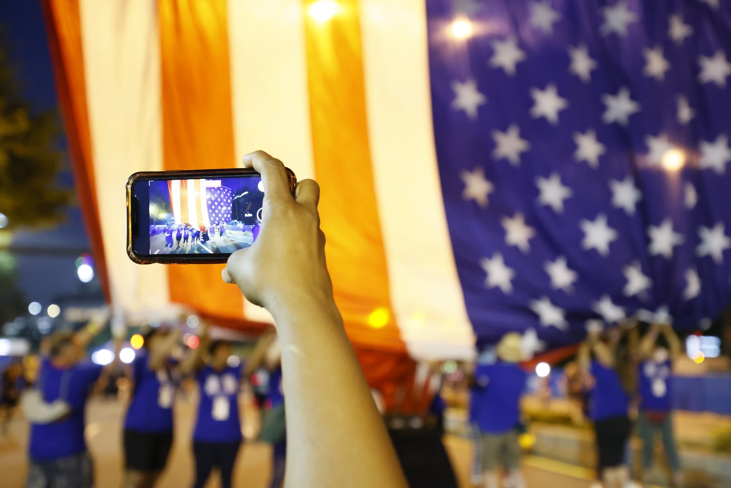 A giant American flag is raised over the start line of the 53rd running of the Atlanta Journal-Constitution Peachtree Road Race in Atlanta on Sunday, July 3, 2022. (Miguel Martinez / Miguel.Martinezjimenez@ajc.com)