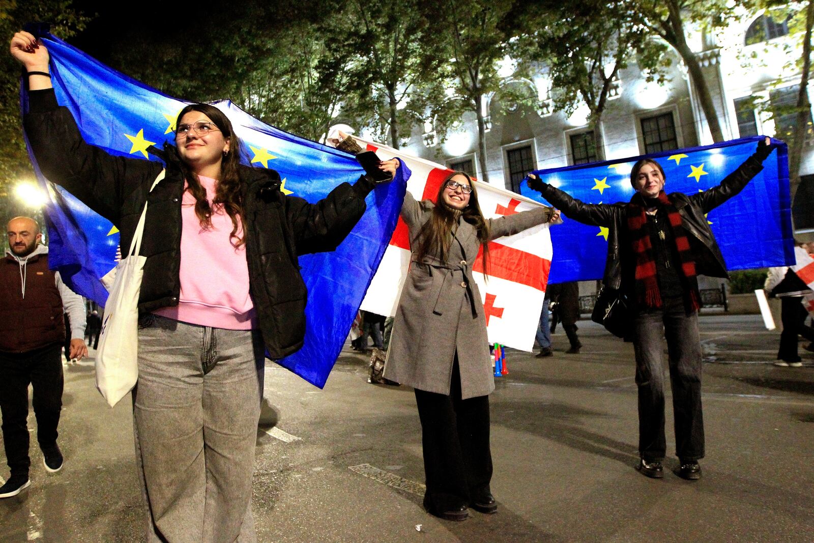 People hold EU and Georgian flags during an opposition protest against the results of the parliamentary election in Tbilisi, Georgia, Monday, Oct. 28, 2024. (AP Photo/Shakh Aivazov)