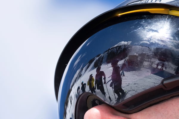 Ukrainian veterans and instructors are reflected in ski goggles as they talk during a lesson with Oregon Adaptive Sports on the three track skiing method at Hoodoo Ski Area in central Oregon on Thursday, March 6, 2025. (AP Photo/Jenny Kane)