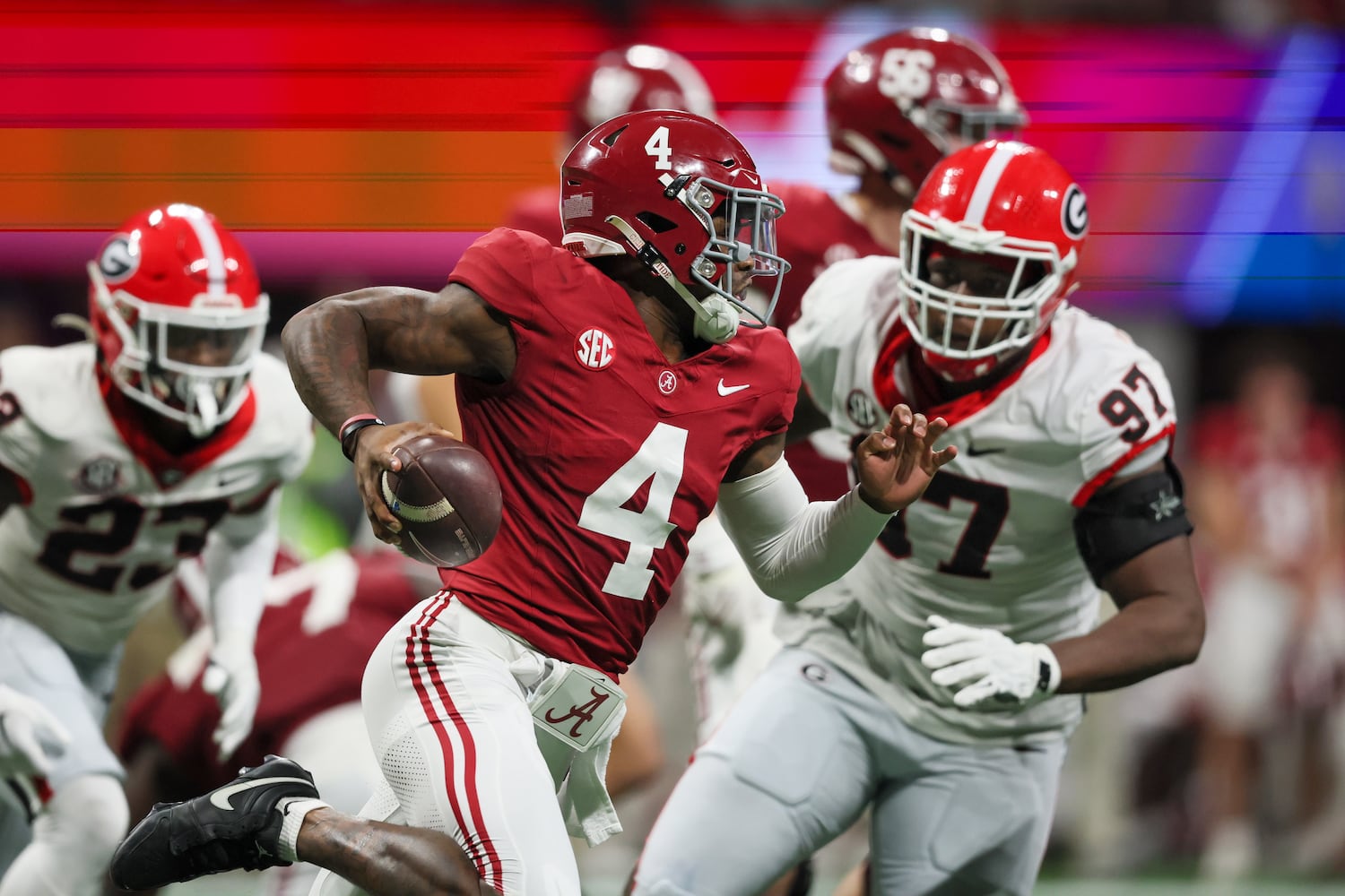 Alabama Crimson Tide quarterback Jalen Milroe (4) runs past Georgia Bulldogs defensive lineman Warren Brinson (97) during the second half of the SEC Championship football game at the Mercedes-Benz Stadium in Atlanta, on Saturday, December 2, 2023. (Jason Getz / Jason.Getz@ajc.com)