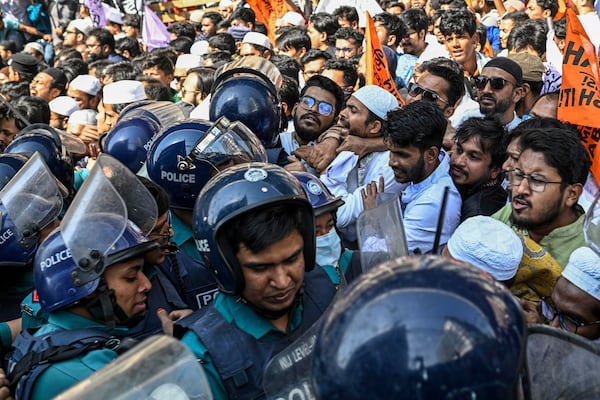 Policemen stop members and supporters of the banned Islamist group Hizbut Tahrir during a march near Baitul Mokarram Mosque in Dhaka, Bangladesh, Friday, March 7, 2025. (AP Photo/Mahmud Hossain Opu)