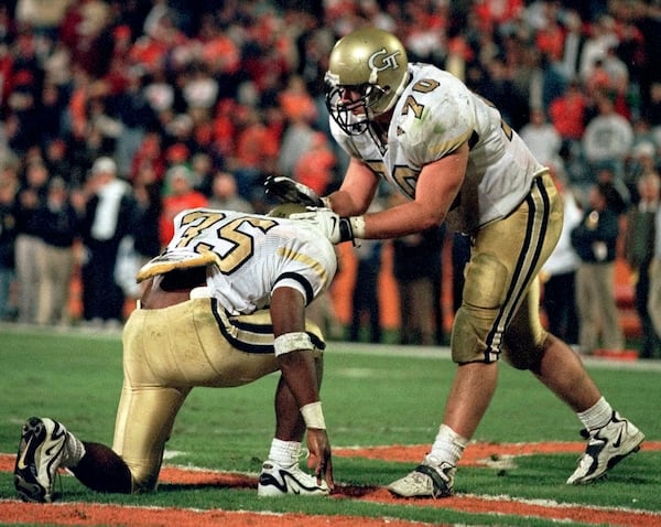 Georgia Tech's Joe Burns (35) takes a moment after scoring the winning touchdown against Clemson on Thursday, Nov. 12, 1998, as his teammate Brent Key (70) pats him on the helmet at Memorial Stadium in Clemson, S.C. Georgia Tech defeated Clemson 24-21. (AP Photo/Patrick Collard)