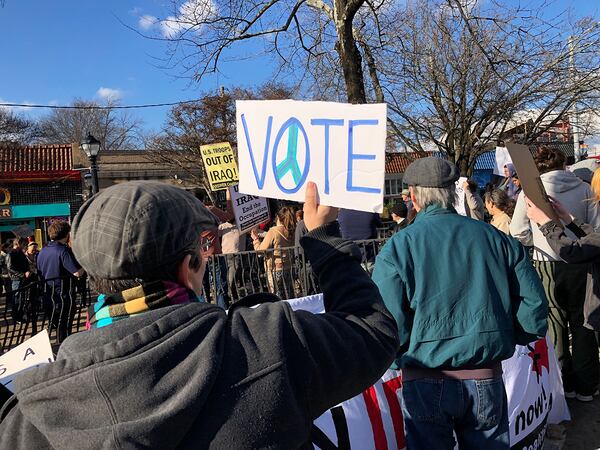 A protester during the Answer Coalition-organized rally in Little Five Points holds a sign encouraging people to vote. The Atlanta rally was one among several such events against American military action in Iraq and other parts of the Middle East scheduled in cities across the U.S. on Saturday, January 4, 2019. (Photo: Leon Stafford/AJC)