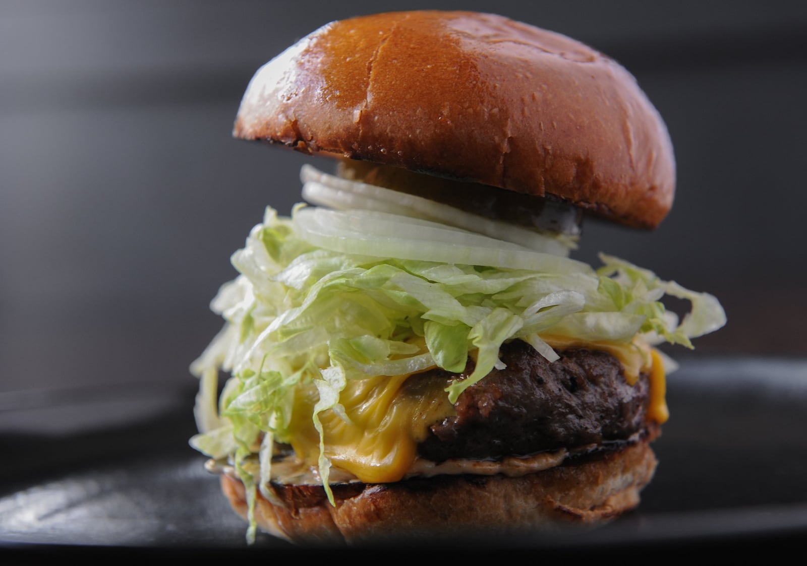 The Hank, served at Illegal Food, is a house-ground burger served with American cheese, shredded iceberg, sweet Vidalia onion, house-made dill pickle and special sauce. (Becky Stein / beckysteinphotography.com)