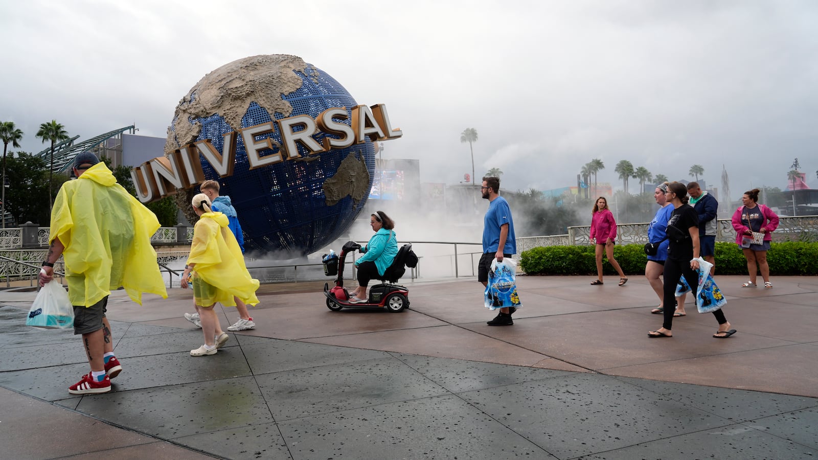 Tourists walk along Universal Orlando Resort city walk before the park closed early for the arrival of Hurricane Milton, Wednesday, Oct. 9, 2024, in Orlando, Fla. (AP Photo/John Raoux)