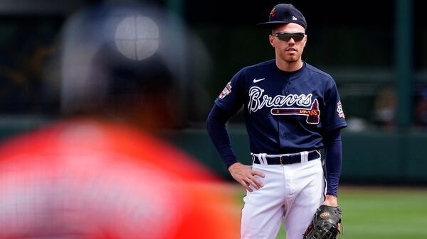 Atlanta Braves first baseman Freddie Freeman wears his hat sideways as he waits for Boston Red Sox's Xander Bogaerts (2) to bat during the first inning Tuesday, March 23, 2021, at CoolToday Park in North Port, Fla. (John Bazemore/AP)