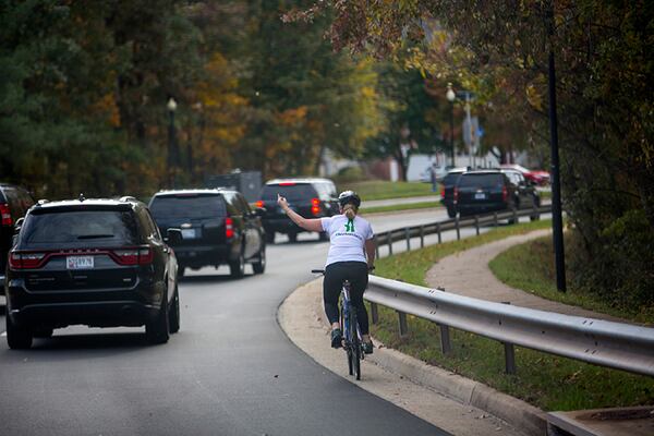 Juli Briskman gestures at President Donald Trump's motorcade in October 2017. Briskman, who lost her job over the incident, has won local office in a district that includes one of Trump's golf courses.