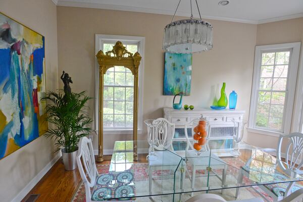 Colorful glass, bronze statues, classical accent pieces in gold and a 1980s abstract painting from King Galleries in Roswell brighten the airy dining room in the home of Jeffrey Chandler and Pedro Ayestaran Diaz. Text by Lori Johnston and Keith Still/Fast Copy News Service. (Christopher Oquendo Photography/www.ophotography.com)