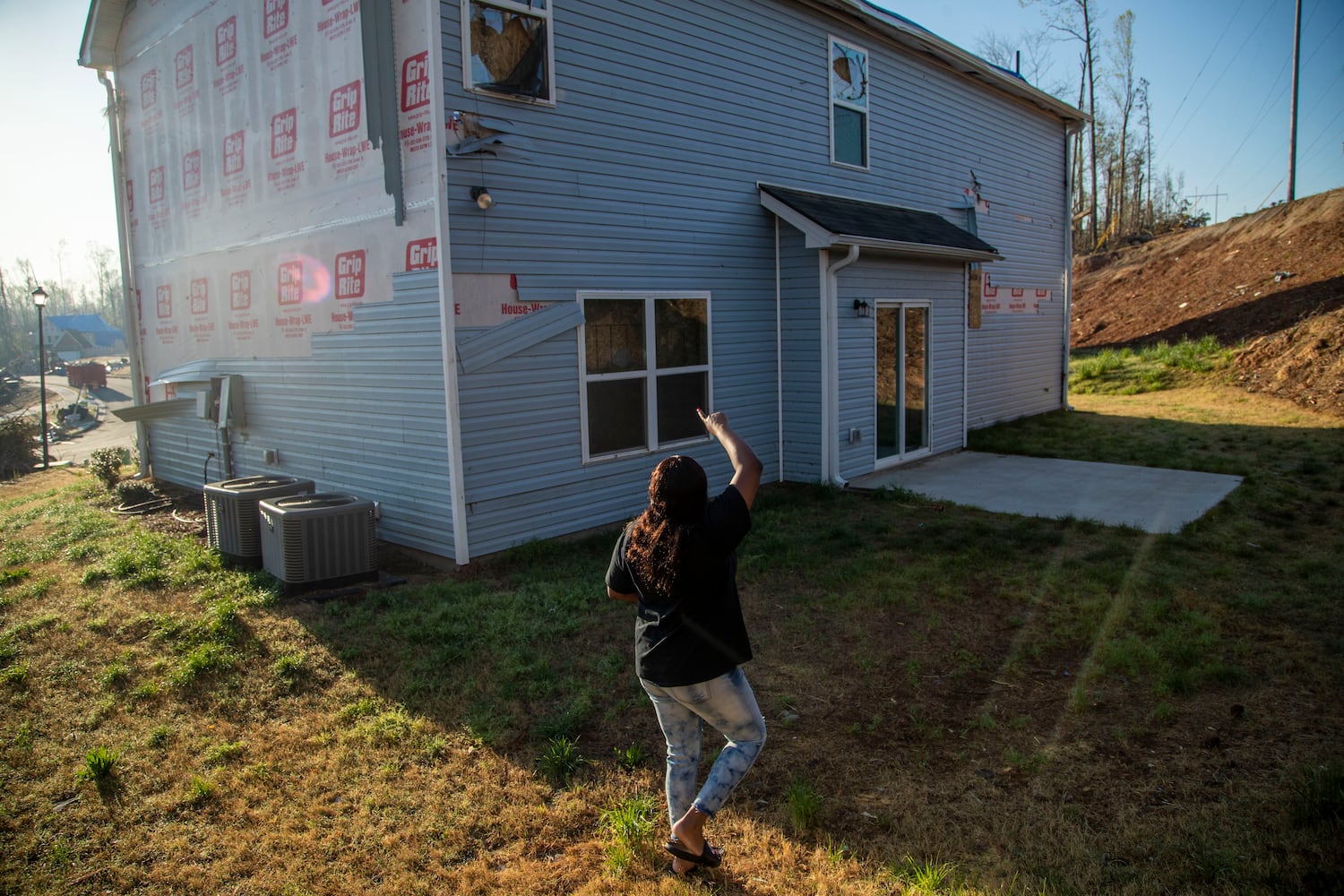 Brittany Mitchell points out the damage her house sustained from the tornado. The family had lived in the newly built home for almost a year. Although the house is still standing, the damage created by the tornado, which warped the house from its foundation, has caused them to rebuild from the ground up. (Alyssa Pointer / Alyssa.Pointer@ajc.com)