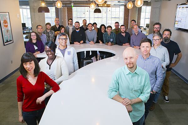 The staff of How Stuff Works gathers at the company’s signature question mark table. CONTRIBUTED BY HOW STUFF WORKS