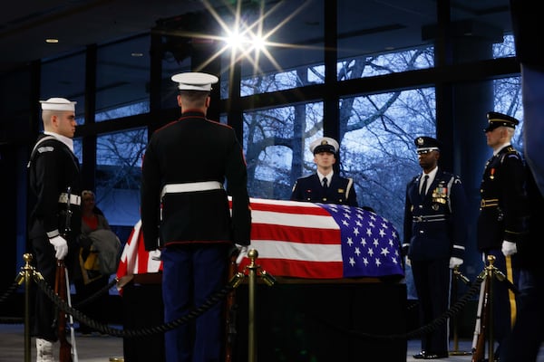 The Honor Guard surrounds the flag-draped casket of former President Jimmy Carter at the Carter Center on Monday.