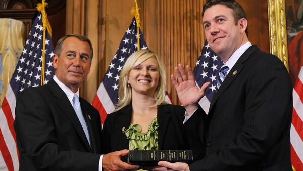 In this Jan. 5, 2011, file photo, House Speaker John Boehner of Ohio, left, administers the House oath to Rep. Duncan Hunter, R-Calif., as his wife, Margaret, looks on during a mock swearing-in ceremony on Capitol Hill in Washington.