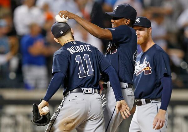 Braves pitcher Julio Teheran playfully puts the pitcher's rosin bag atop the cap of center fielder Ender Inciarte (11) after Inciarte robbed New York Mets' Yoenis Cespedes of a game-winning, three-run home run for the final out in the Braves 4-3 victory over the Mets Sept. 21, 2016, in New York. 