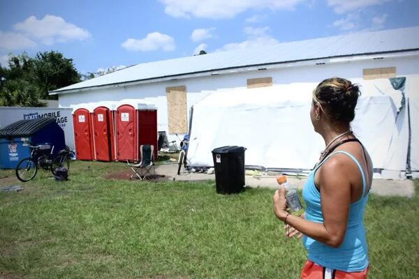 A woman experiencing homelessness sits outside of a homeless encampment at 1803 G Street. She is one of about 20 people who stay here since The Well temporarily closed. (Photo Courtesy of Kailey Cota)