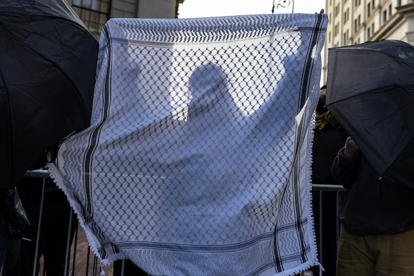 A student from Columbia University holds up a keffiyeh as they line up to enter Manhattan federal court to attend the deportation case of Mahmoud Khalil, Wednesday, March 12, 2025, in New York. (AP Photo/Stefan Jeremiah)