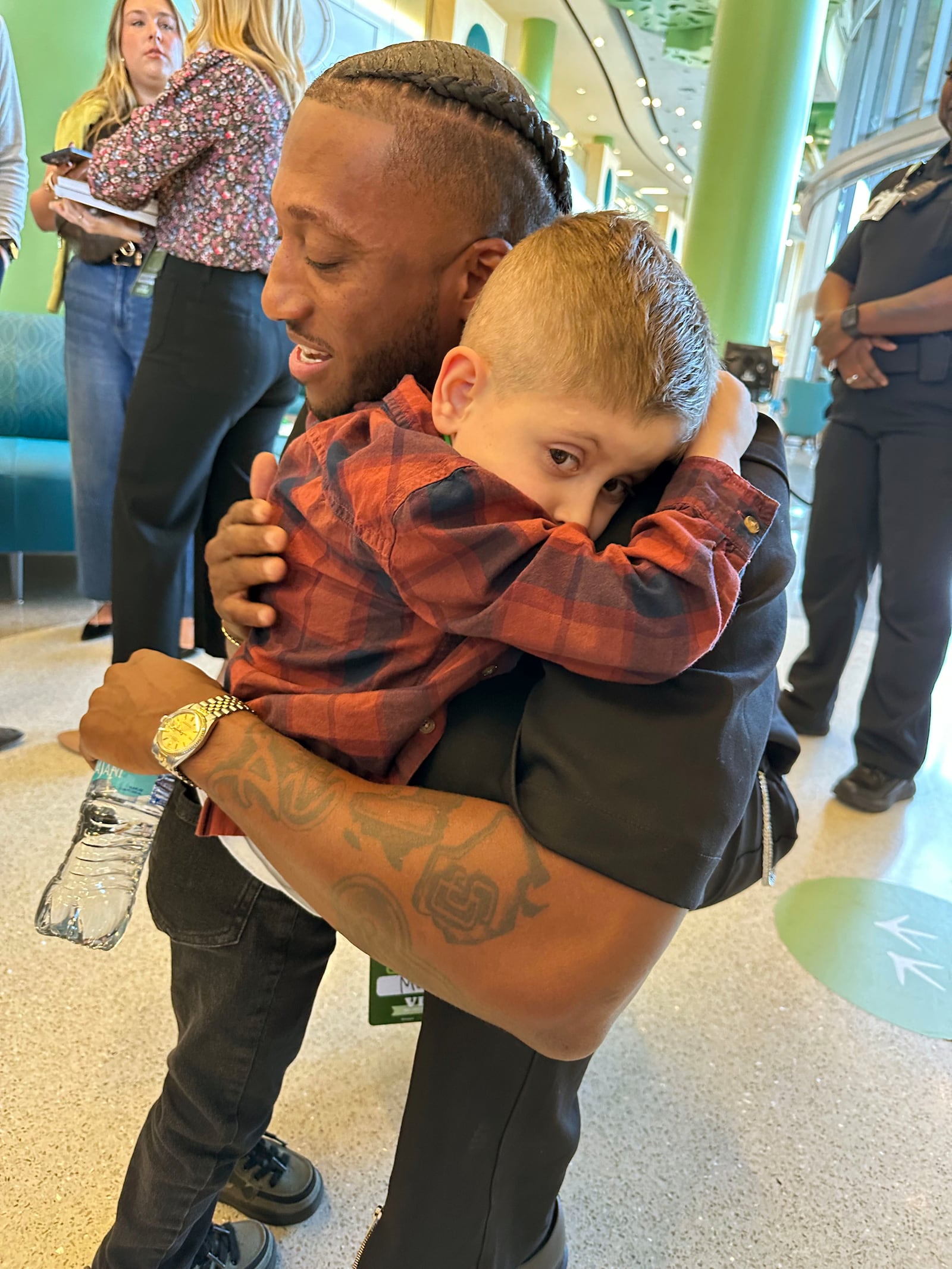 Atlanta Christian hip-hop artist Lecrae hugs Max Munguia, seven, at the opening of Seacrest Studios at Children's Healthcare of Atlanta Arthur M. Blank Hospital on Oct. 11, 2024. Max has spina bifida and placed in a HALO traction at CHOA for four to six weeks. RODNEY HO/rho@ajc.com