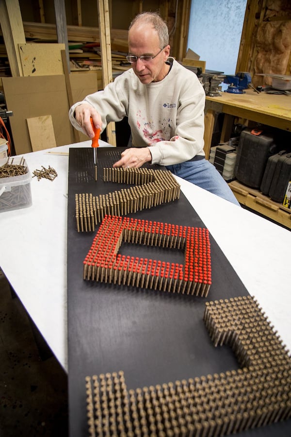 Dr. Scott Shulman drives some of the 1,830 deck screws into one of his projects at his home shop in Sandy Springs. He works during weekends in the unfinished area of his basement creating a range of projects. Though Shulman doesn’t consider himself an artist, he has developed a following over the years among friends, family and organizations who have requested his work. STEVE SCHAEFER / SPECIAL TO THE AJC